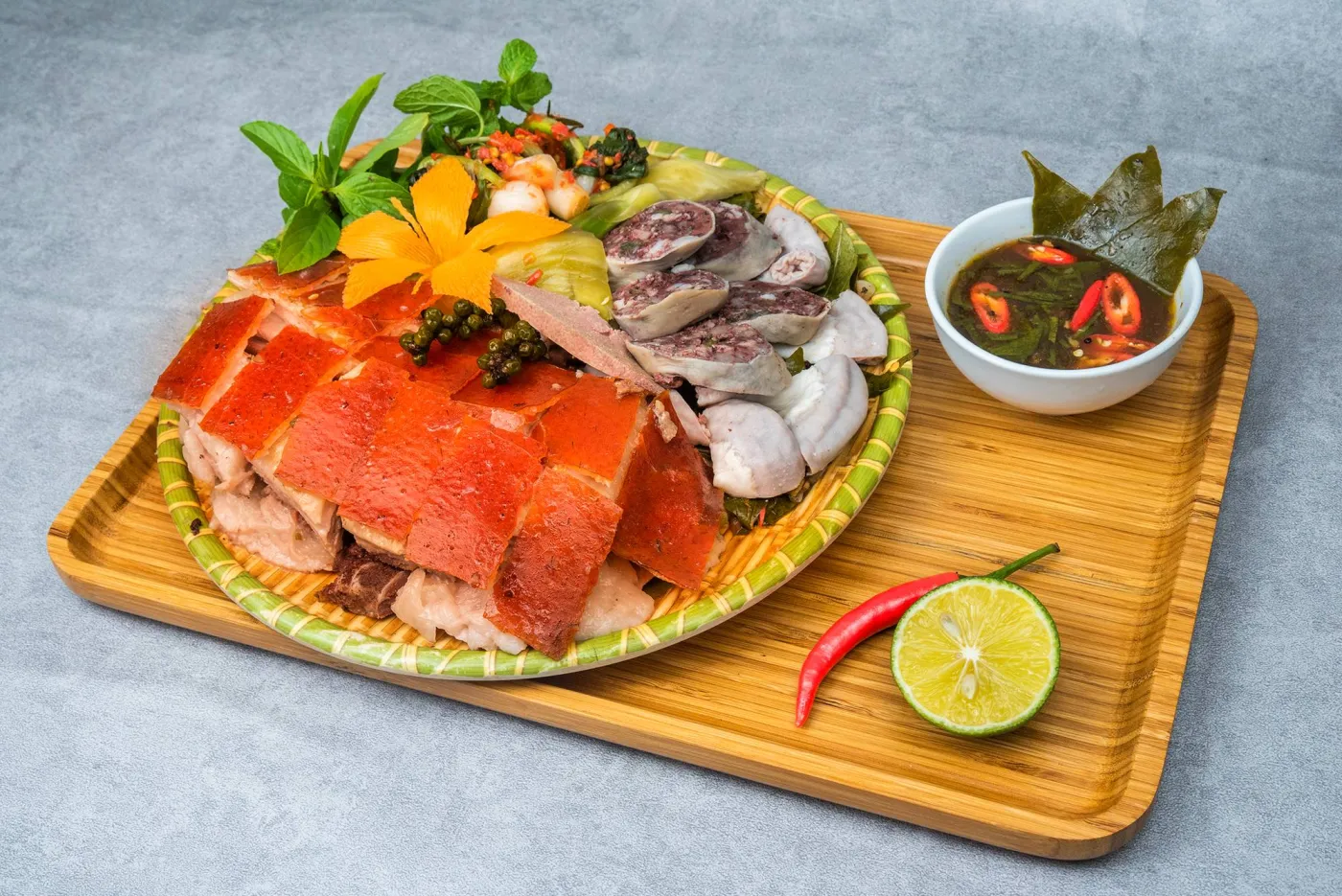 Mâm lợn mẹt với lợn quay, dồi, lòng và rau thơm